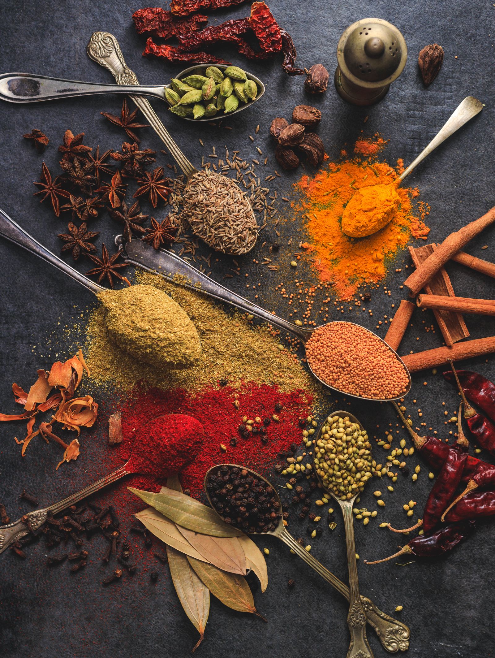 スプーンに盛られた色とりどりの香辛料と食品素材